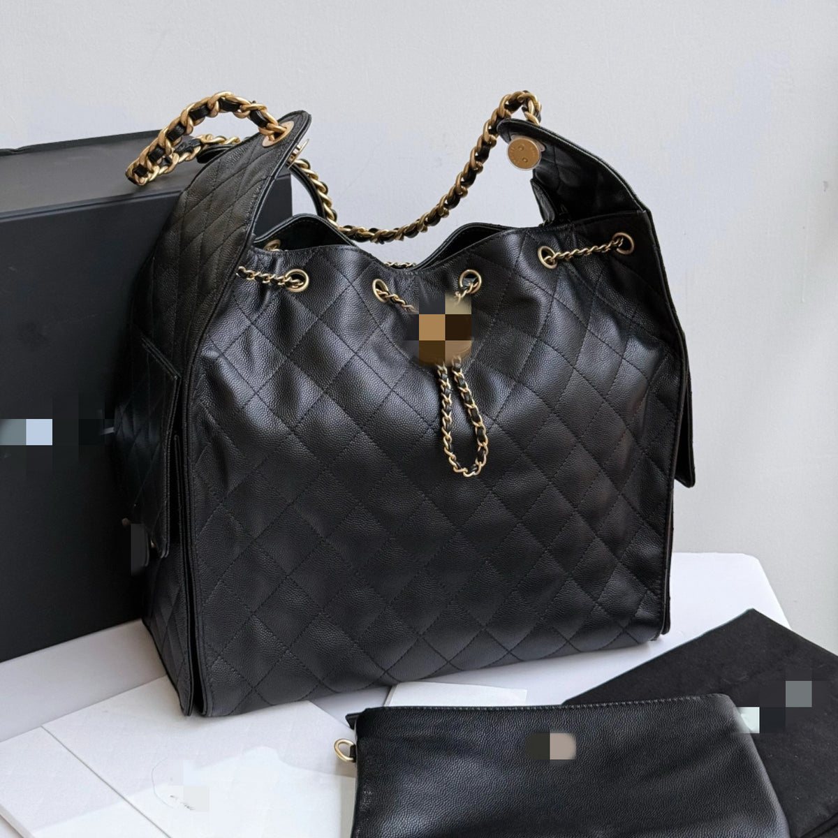 Bolsa C preta elegante, com alça de ombro em metal dourado e amplo espaço interno