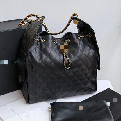 Bolsa C preta elegante, com alça de ombro em metal dourado e amplo espaço interno