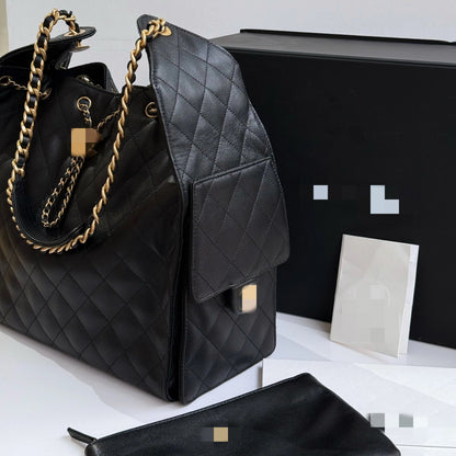 Bolsa C preta elegante, com alça de ombro em metal dourado e amplo espaço interno